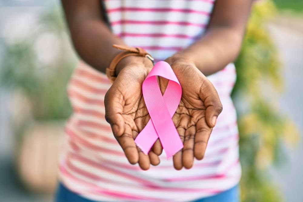 AdobeStock_400434305 resized Hands holding cancer ribbon to represent breast cancer