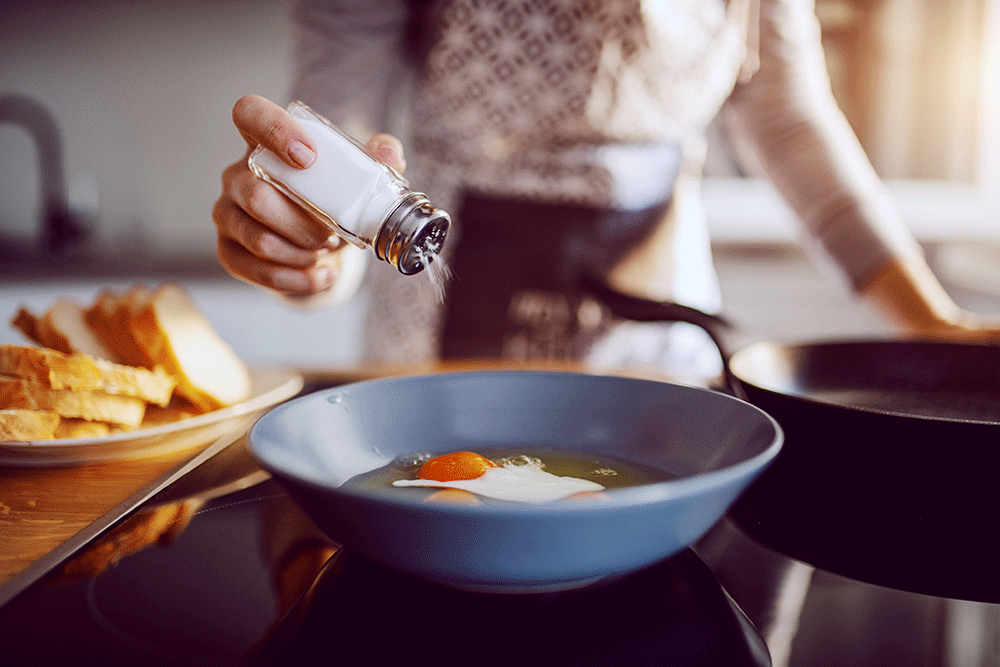 Salt awareness Person shaking salt on food