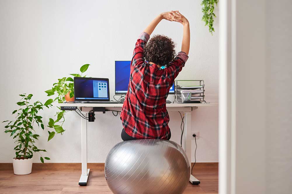 Employee doing some stretches on work break at desk